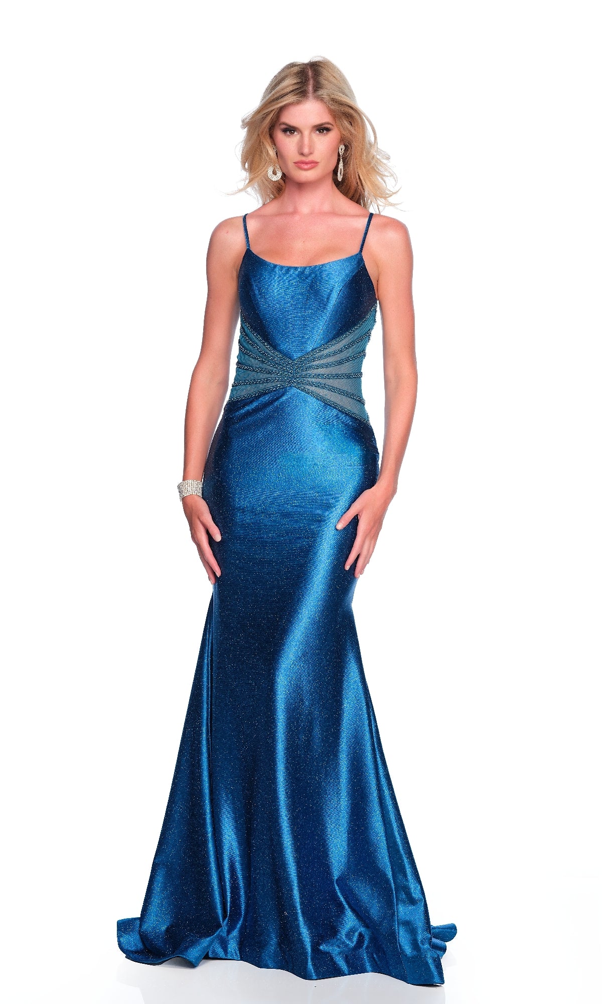 A woman stands against a white background wearing the Teal Blue Glitter Prom Dress: Dave & Johnny 12042, a floor-length gown with thin straps, side ruching, and a mermaid silhouette. She accessorizes with earrings and a bracelet.